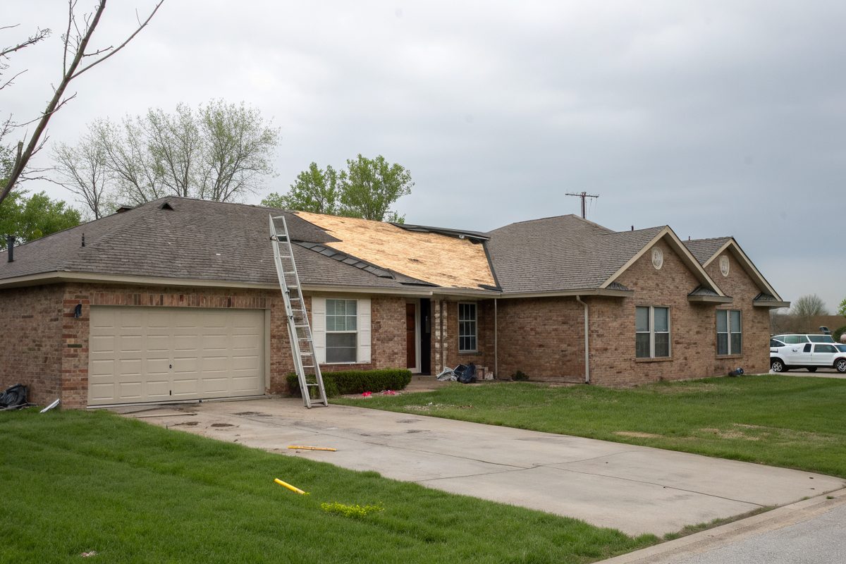 A ranch house roof stripped to its wood decking during a tear-off